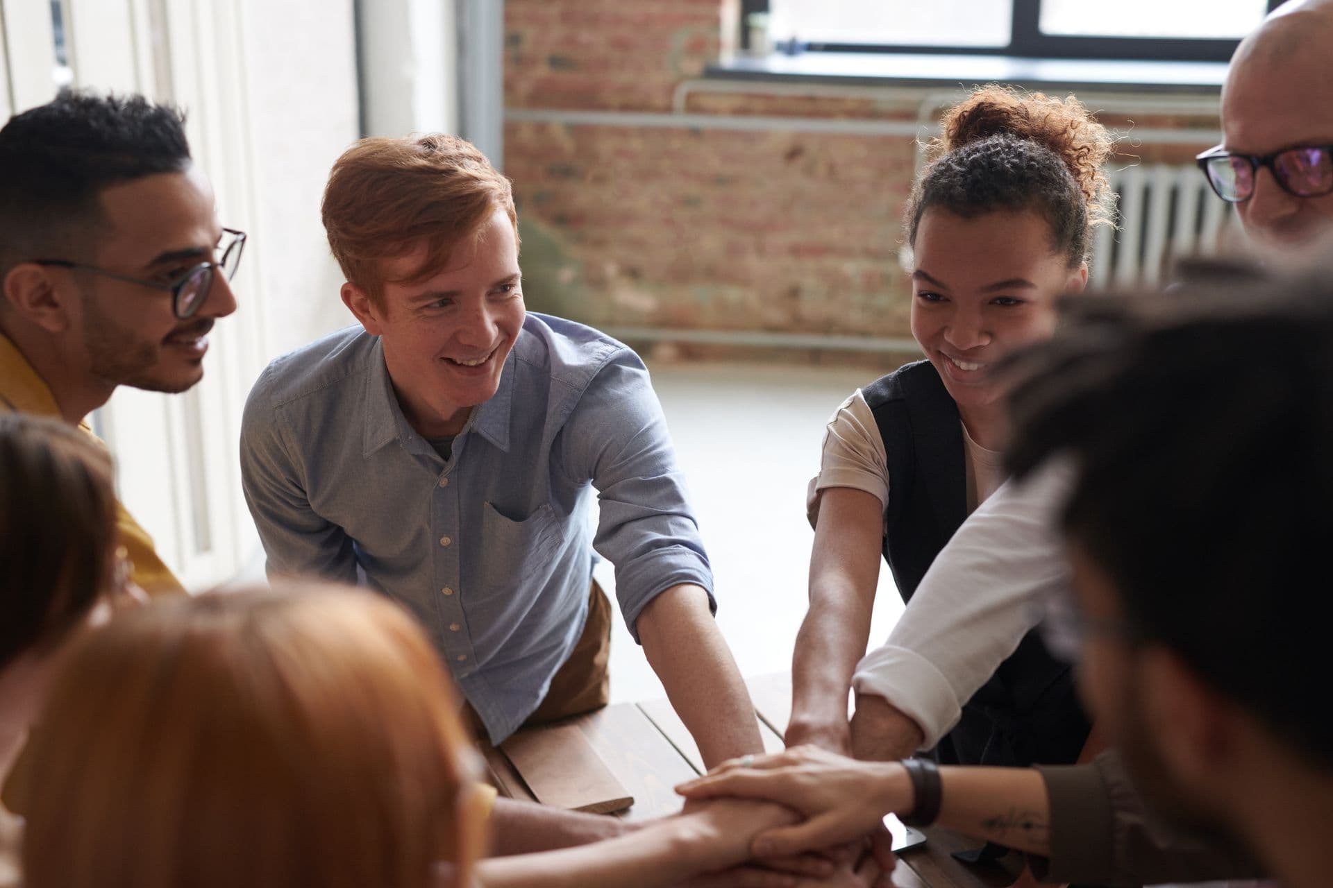Groep collega's die de handen ineenslaan