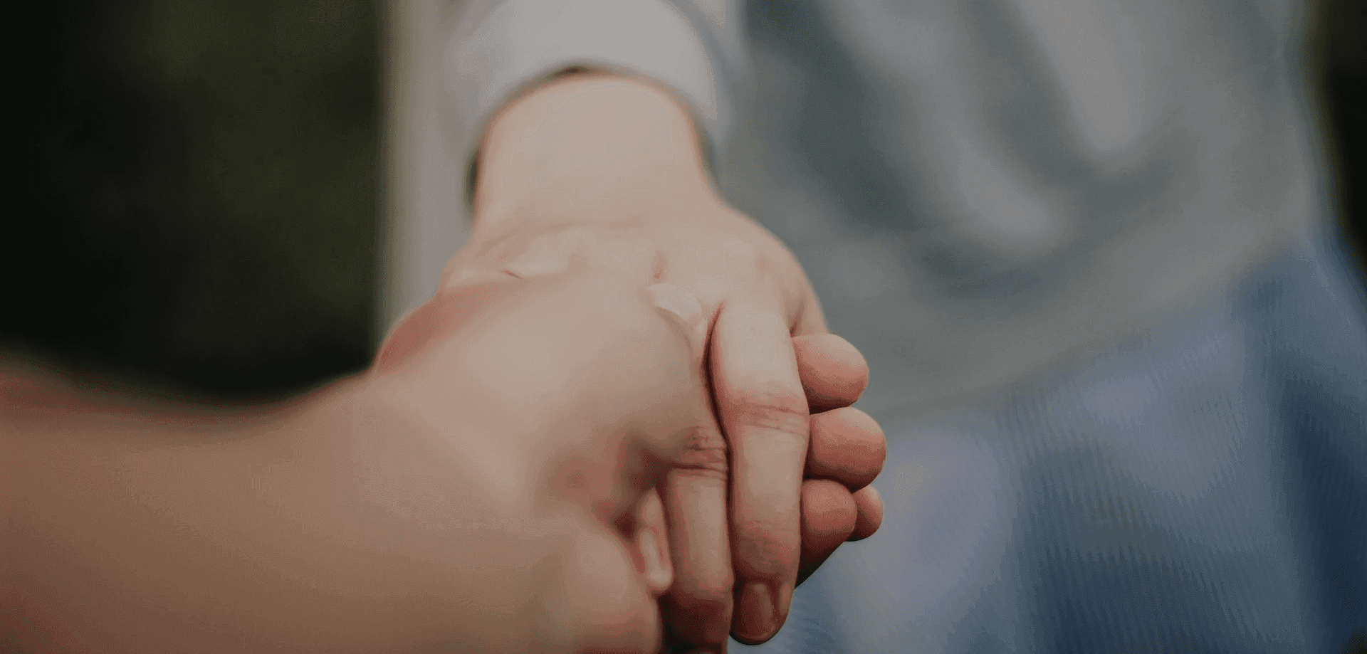 Twee mensen die elkaars hand vasthouden