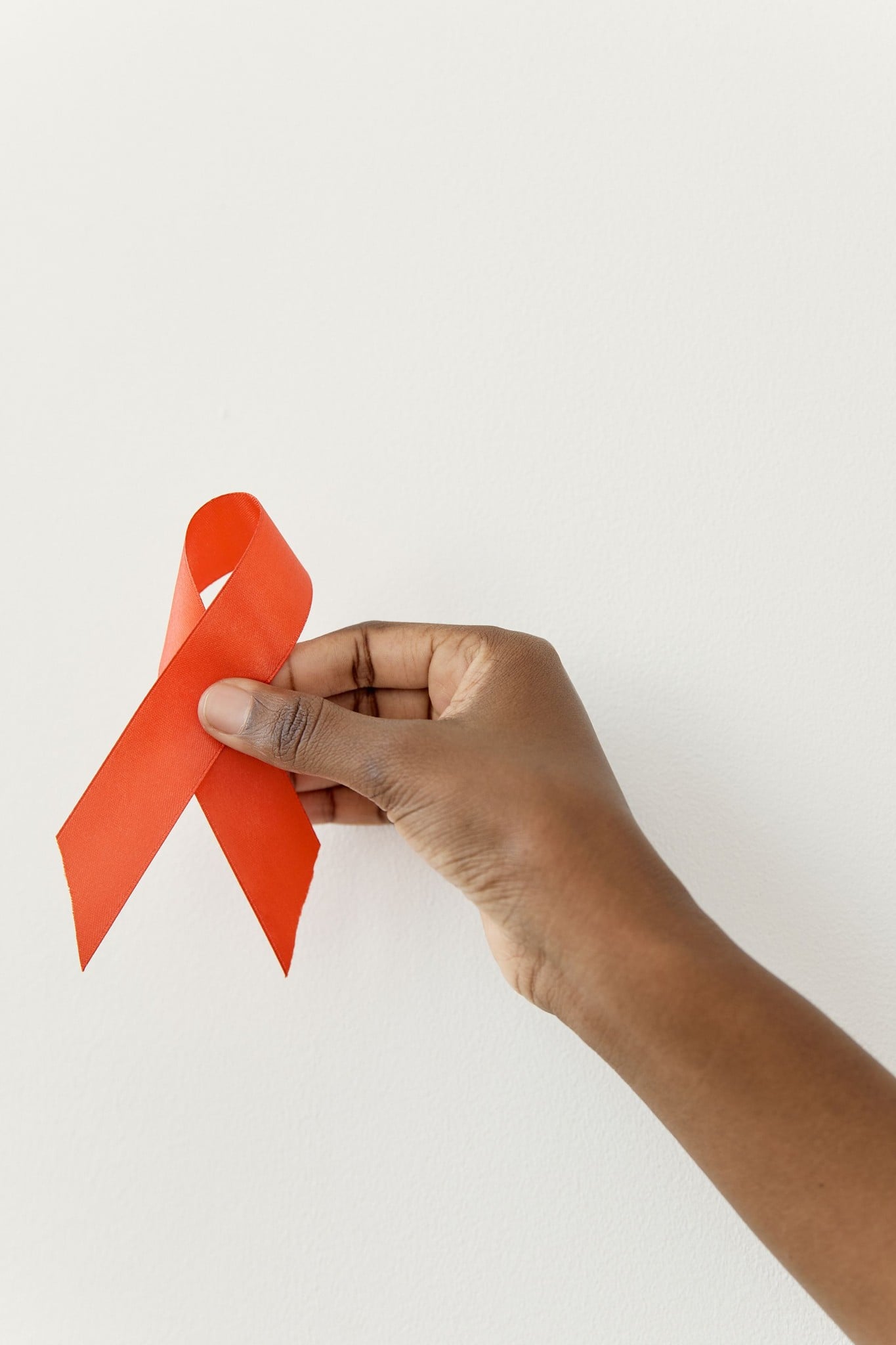 Hand die een rood aidslintje vasthoudt